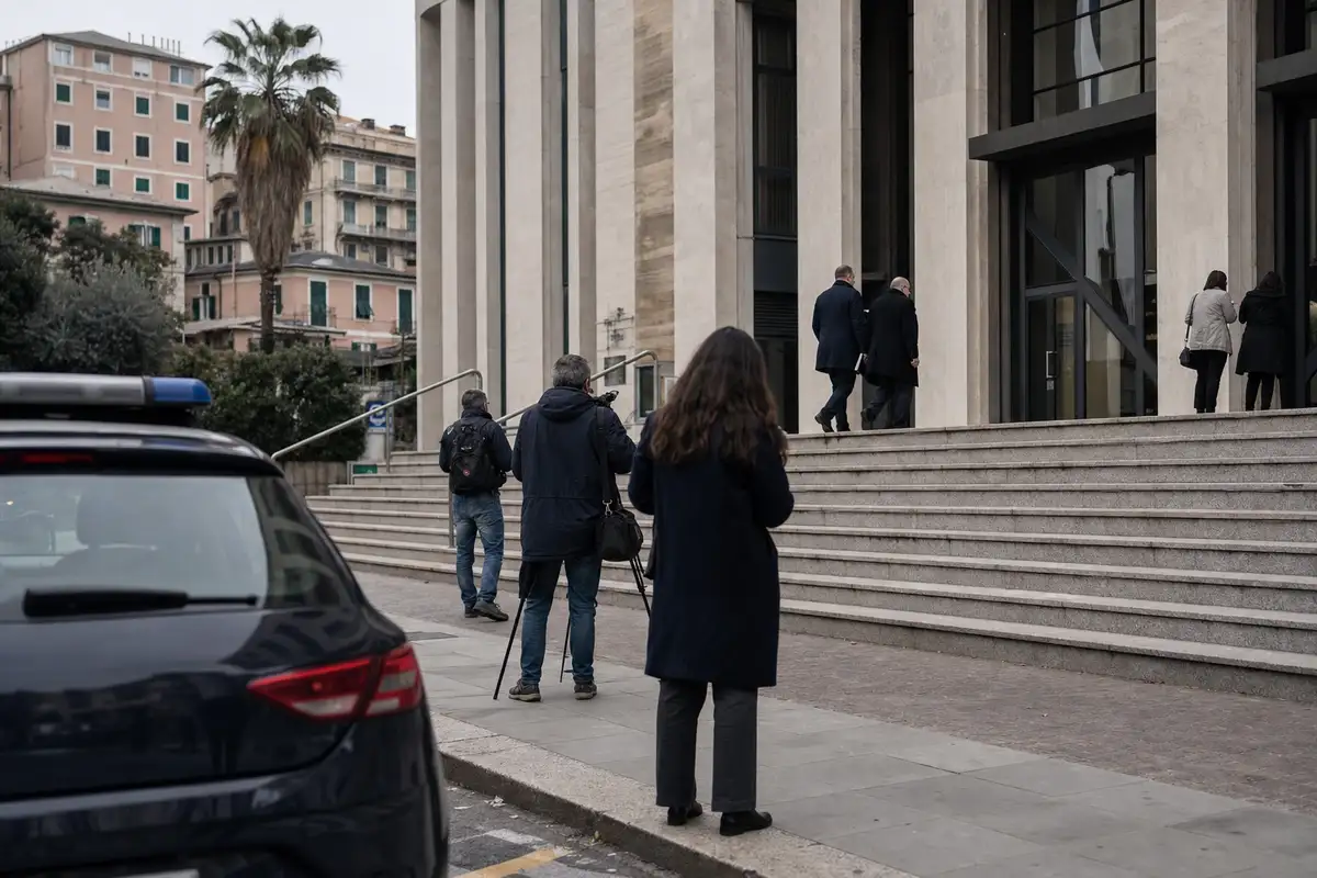 Ingresso di un tribunale con giornalisti e cameraman sulle scale e auto della polizia in primo piano