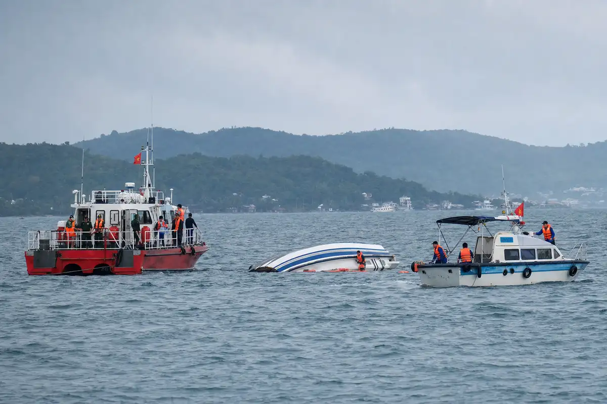 Imbarcazioni di soccorso affiancano un motoscafo capovolto in mare, con operatori in giubbotti arancioni
